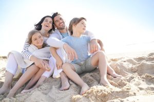 Eine Familie sitzt gemeinsam am Strand und genießt den Moment – Symbolbild zum Thema Demenz vorbeugen