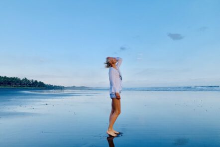 Kerstin Hardt steht am Strand und strahlt die Vitalität aus, die von Hybrid Training kommt: Die beste Bewegung für Gesundheit