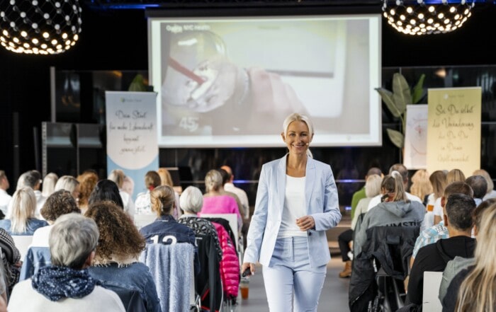 Kerstin Hardt in einem blauen Anzug im Mittelgang ihres Seminares Energize your Life, bei dem es auch auch um Mindset stärken geht