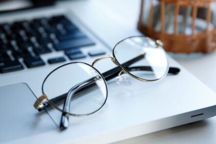 Eine Brille auf einem Computer steht sinnbildlich dafür, wie wichtig es ist, regelmäßig etwas für die eigene Sehstärke zu verbessern.