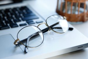 Eine Brille auf einem Computer steht sinnbildlich dafür, wie wichtig es ist, regelmäßig etwas für die eigene Sehstärke zu verbessern.